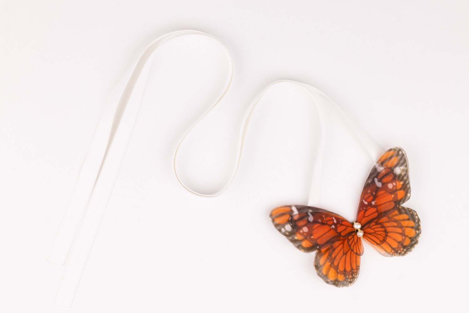 Butterfly Ribbon Tie - Monarch, White Ribbon Oana Savu Handmade ribbon tie accessory is sewn by hand in our little atelier near in Antwerp, Belgium. The voluminous silk butterfly worn around your neck, frames the face, adding a spark of ingenuity to any look. It is sewn on a high-quality silk satin ribbon tie, with a customizable length to fit more styles, worn around your neck - as a choker necklace, style your hair oh hot summer days, around your wrist as a bracelet or even around your waist as a belt for those light summer dresses.